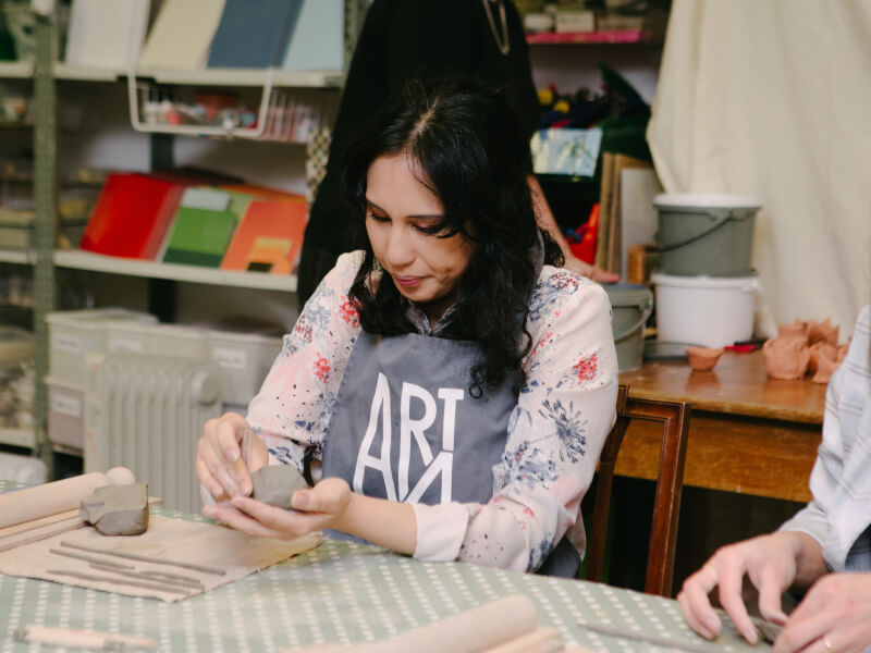 Woman making a pot in a pottery class